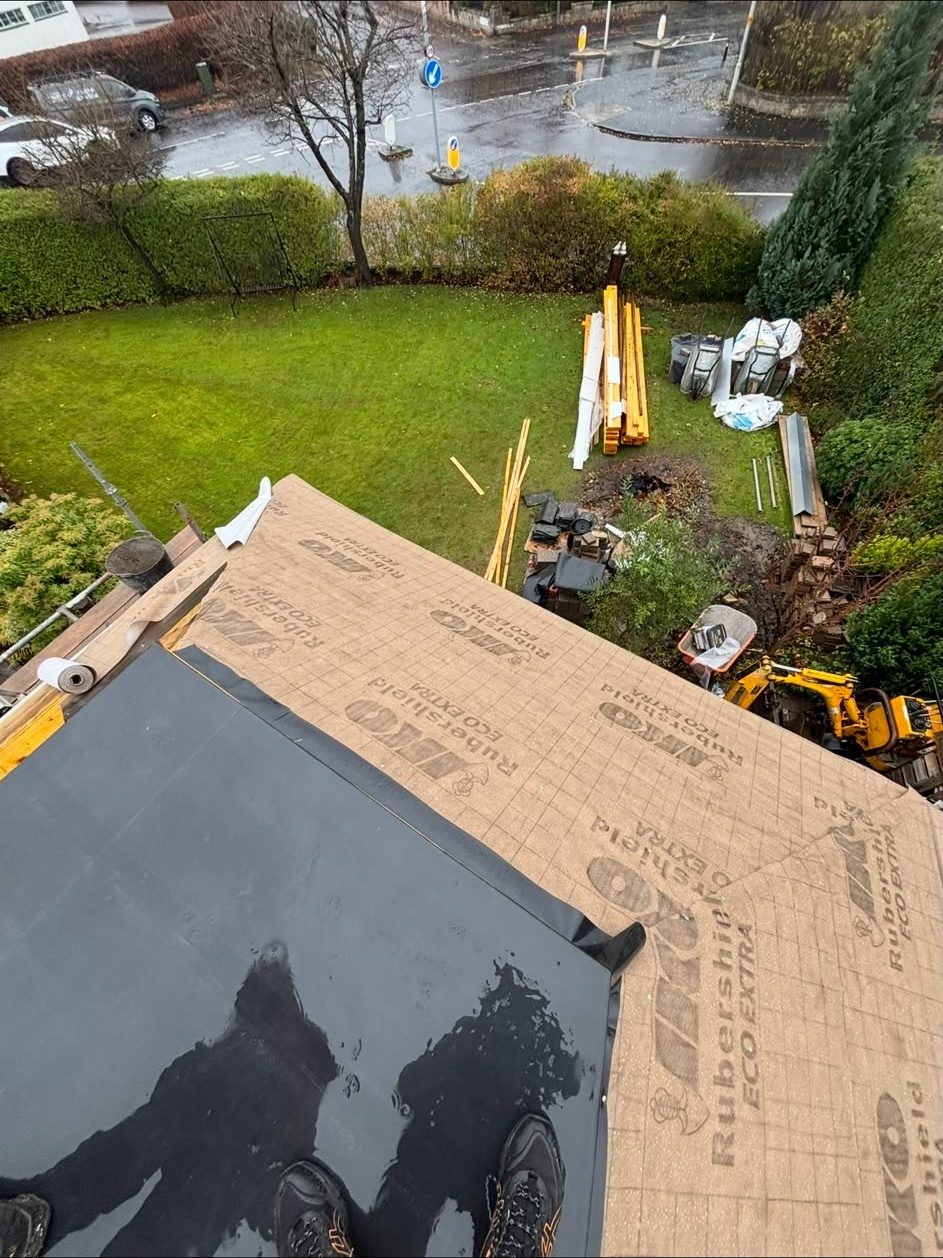 Flat roof being re-felted over new decking above a garden in Edinburgh