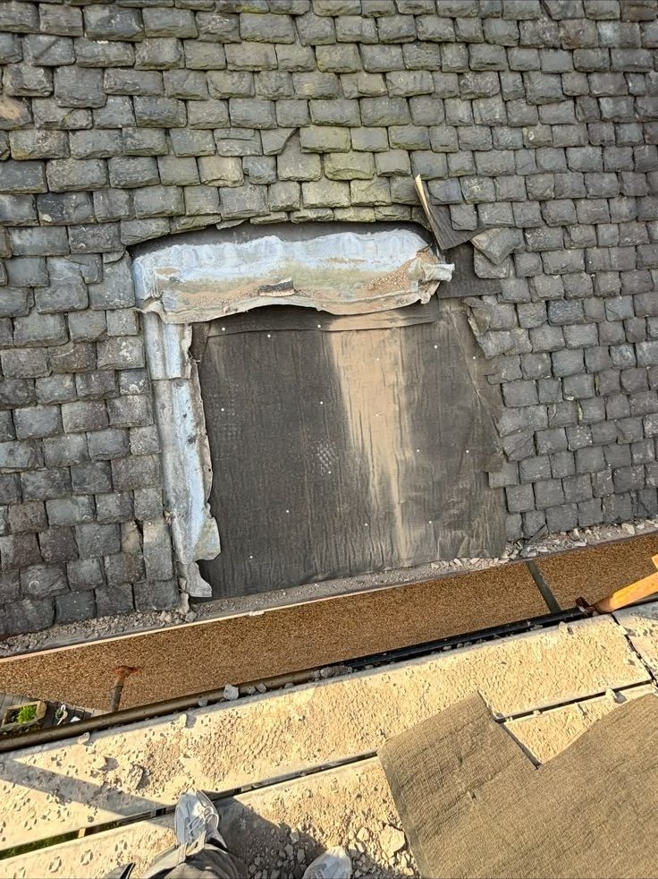 Opening in a slate roof being repaired and boarded, Edinburgh