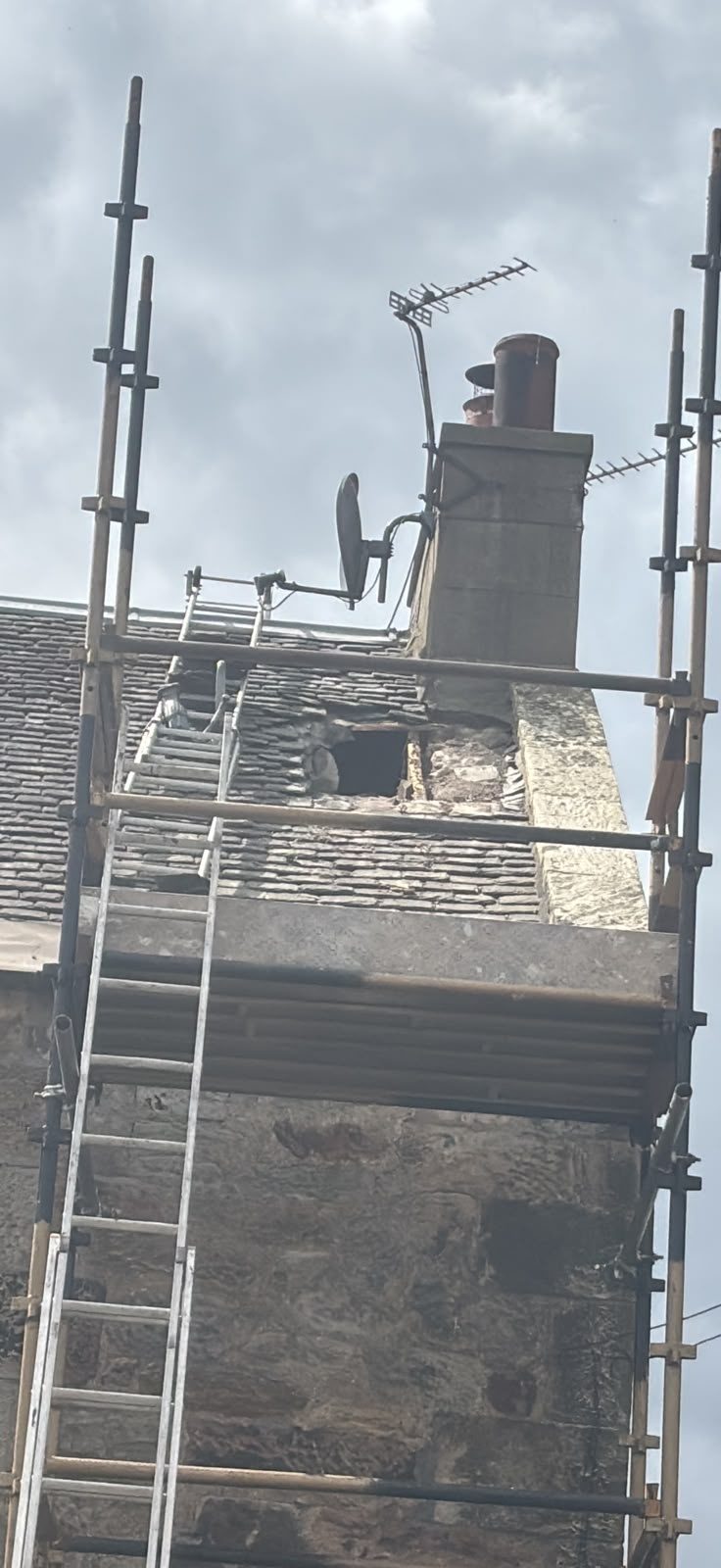 Scaffold and ladder around a chimney stack for emergency roof repairs in Edinburgh