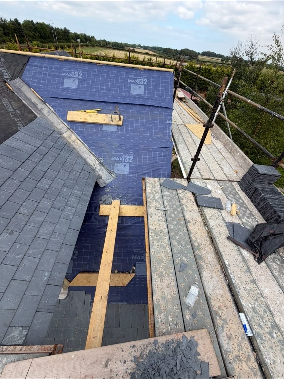 New slates being laid over membrane and battens on a full re-roof, Edinburgh